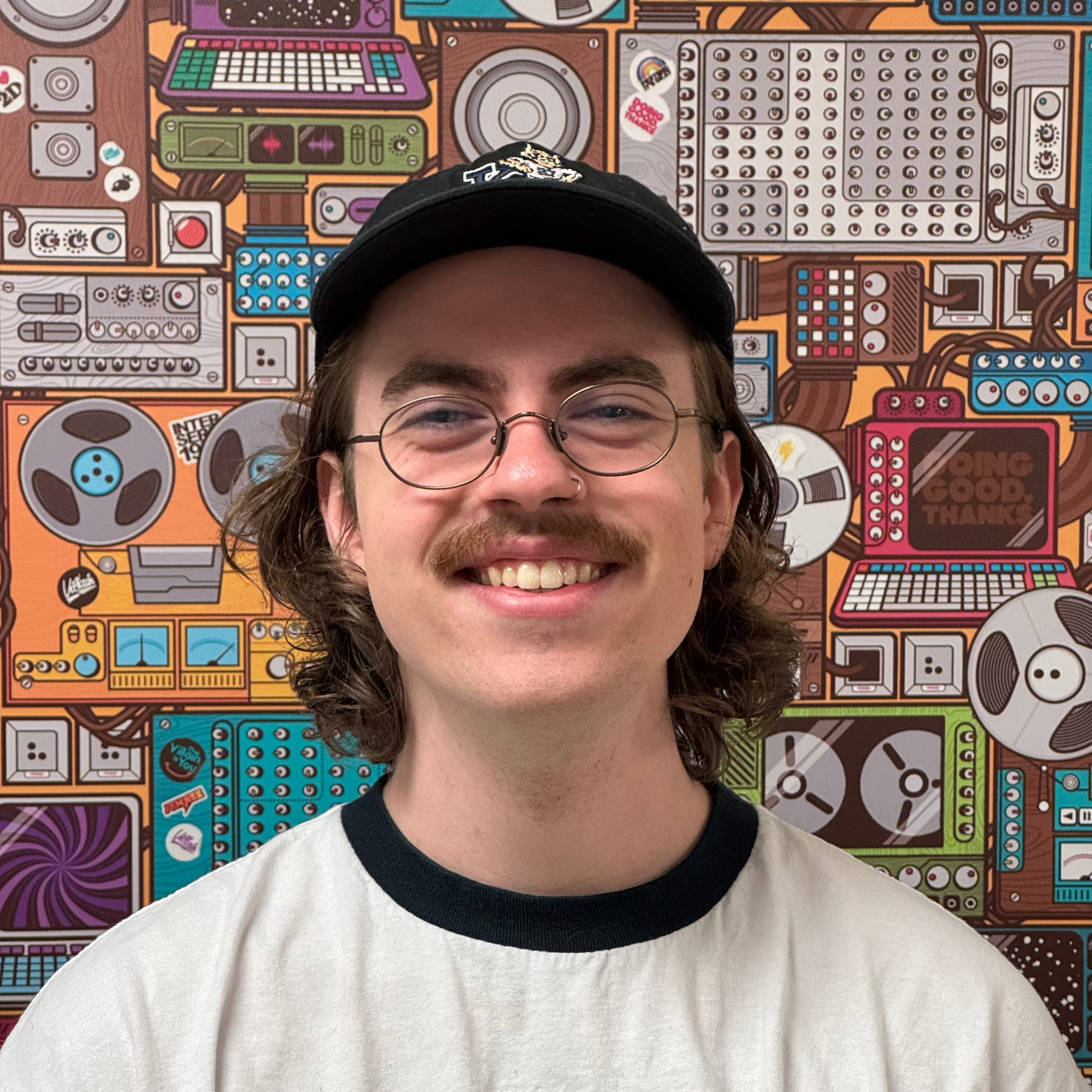 Person wearing an Xbox t-shirt in front of a colorful electronic equipment background